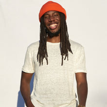 Load image into Gallery viewer, Organia Hemp. Unisex Everyday 100% Hemp Tee. Pictured is a man smiling wearing a beanie wit long dreads and a fun smile. 50% Off with code 2021